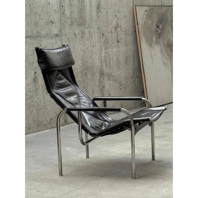 A stunning and rare lounge chair, a design classic by Hans Eichenberger for Strässle International, in black saddle...
