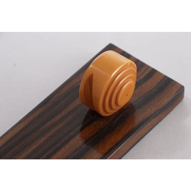 H: 21.5cm w: 25cm d: 6.5cm a french art deco amber phenolic and macassar photo frame.