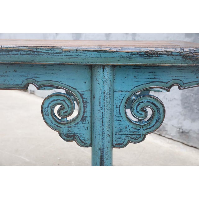 A striking antique Chinese bench crafted from solid elmwood, dating to the late Qing dynasty. The long plank seat rests...