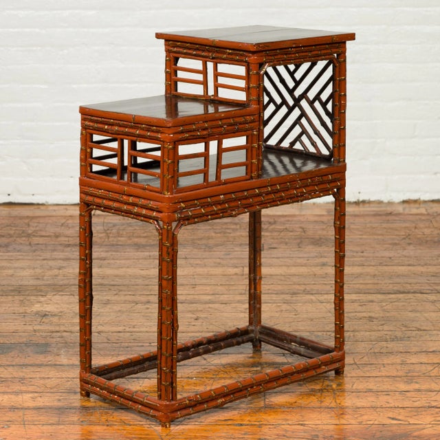 A Chinese vintage tiered bamboo lamp table from the mid-20th century, with geometric patterns. Born in China during the...