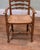 A charming harlequin pair of country ladder-back armchairs Each chair has six shaped back rails, gently curved arms and a...