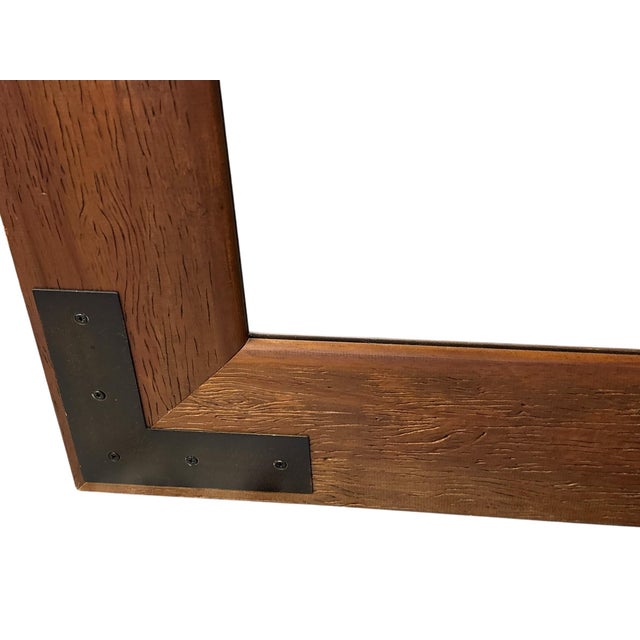 Handsome wall mirror featuring a wide wood frame with decorative black iron corner brackets. A versatile statement piece,...