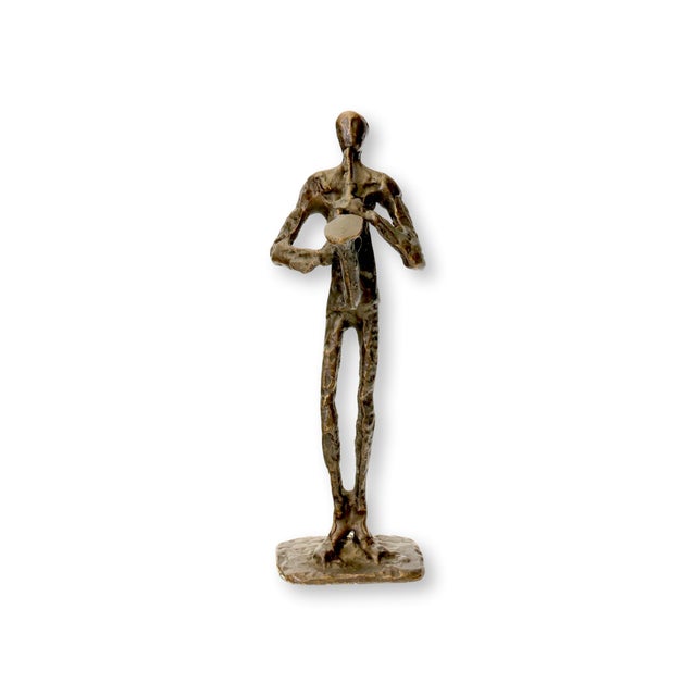 Contemporary bronze jazz musician figure. Hand-cast with textured detail, showing a slender musician playing. Light wear....
