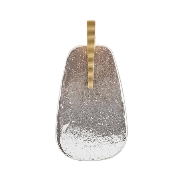 Zelda Wall Sconce features bold Art Deco-inspired geometry with a sculptural smoke-luster glass shade and brass-finished...
