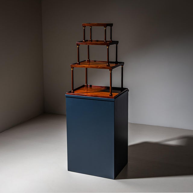 Four-tier étagère of rectangular form with shelves decreasing in size toward the top. The tiers are supported by smooth...