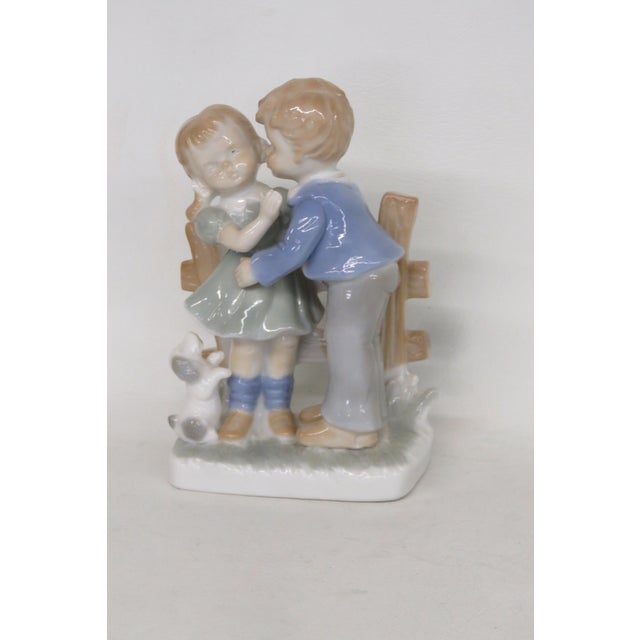 This adorable Boy and Girl Figurine is made out porcelain. This lovely decorative piece is titled "Young Love", presenting...