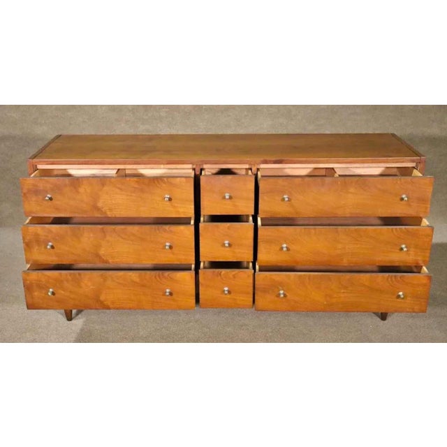 Long Mid-Century Modern dresser with nine drawers. Metal drawer pulls and walnut wood grain. Not stamped