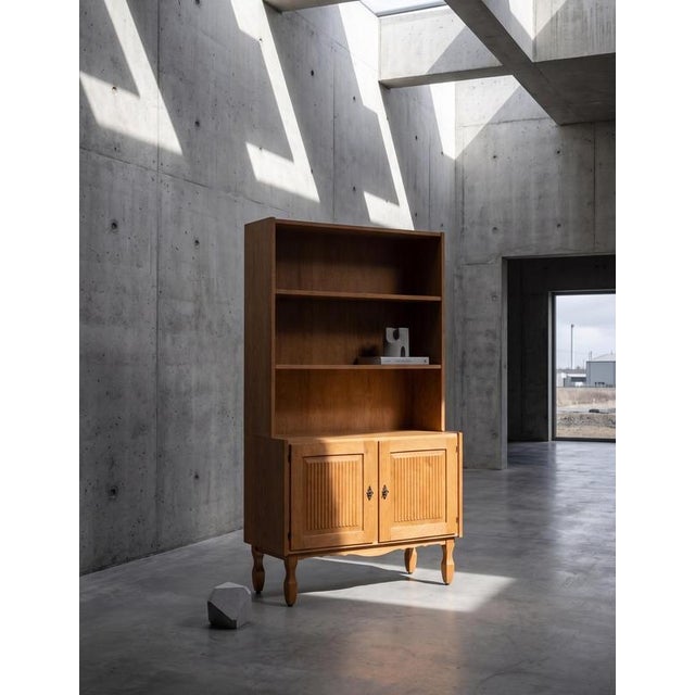 Oak bookcase attributed to Danish designer Henning Kjærnulf, crafted in Denmark during the 1960s. Executed in a...
