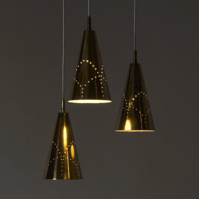 Rare, early ceiling lamp by Hans-Agne Jakobsson. The three brass lampshades are perforated with a pattern that looks...