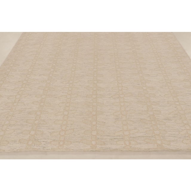This 8x10 contemporary Scandinavian flatweave rug showcases a refined geometric design in soft beige hues. Handwoven in...