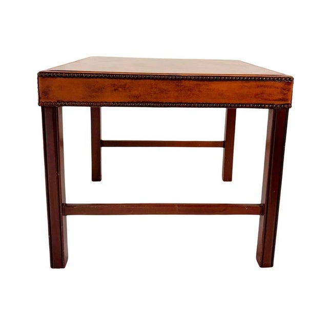 This elegant vintage table, crafted from red mahogany with a leather top and decorative metal rivets, showcases the...