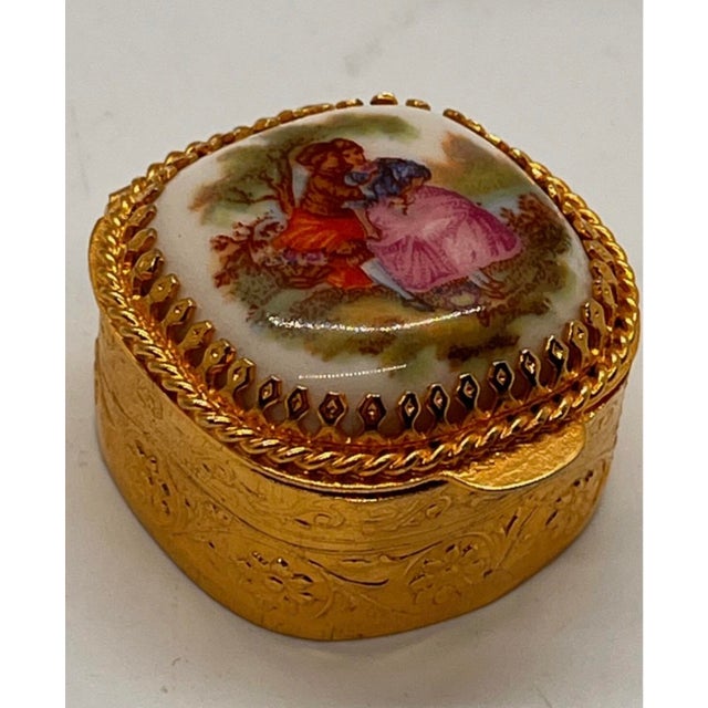 beautiful mid-century vintage gold-tone metal pill or trinket box featuring a classic Rococo romantic courting couple on a...