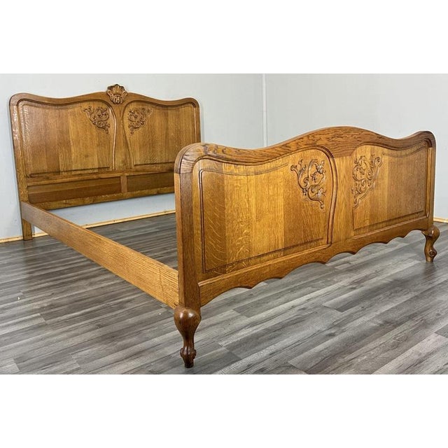This Vintage French Louis double bed frame showcases elegant carved wood panels, curved shaping and a warm oak finish that...