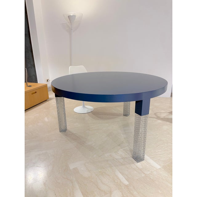 Round dining table produced by Cappellini, featuring an elegant circular top in medium blue stained wood and three chromed...