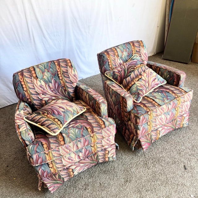 A vibrant pair of vintage swivel rocking lounge chairs featuring bold needlepoint-style upholstery with a tropical Art...