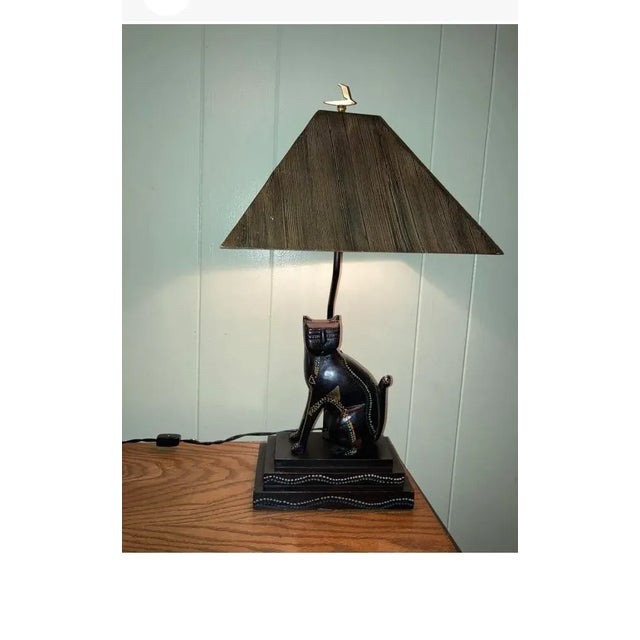 Cool cat made from wood and some metal accents. Has nice matching hard plastic shade. On/off switch is in the cord.