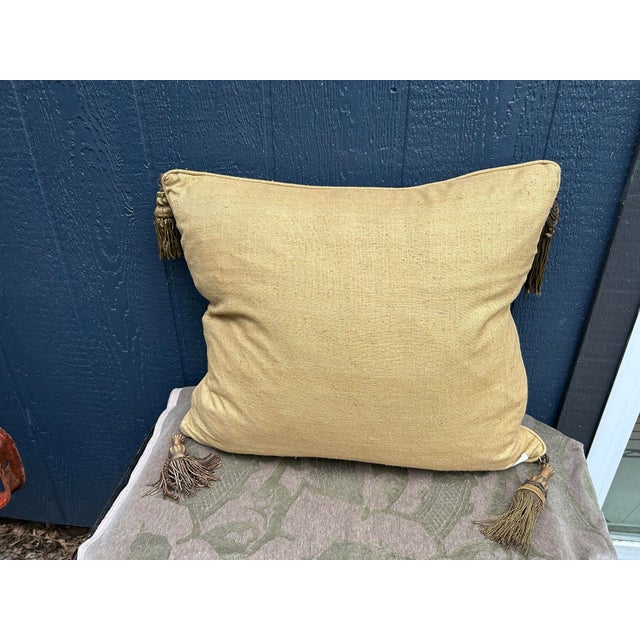 A pillow made from a 19th century woven linen/silk textile with images of dragons and scrolls, embellished with antique...