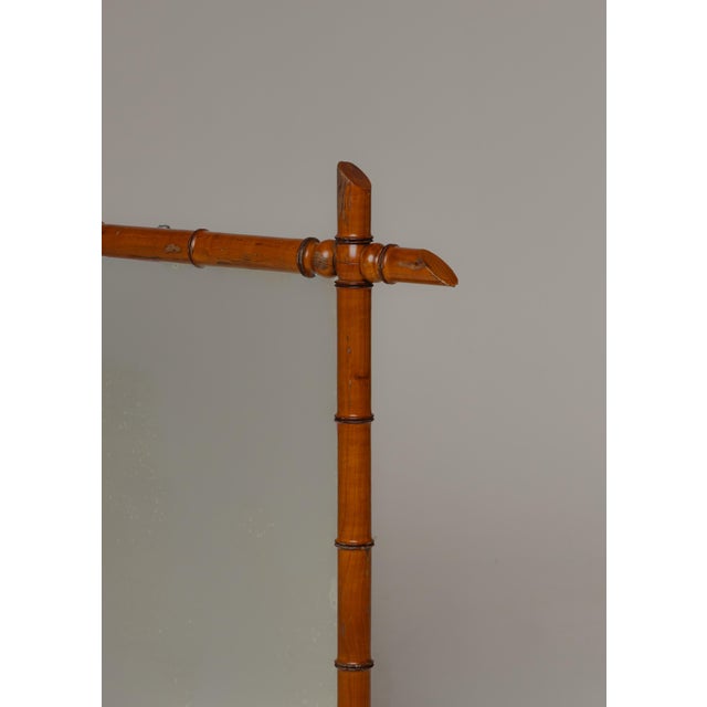 French wall mirror, early 20th c., having turned faux bamboo frame, encasing flat mirror plate, verso retaining label from...