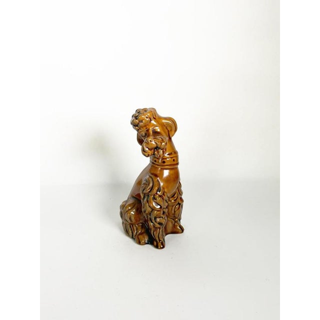Decorative French ceramic dog sculpture dating from the 1970s. The seated dog is depicted with a stylized, expressive...