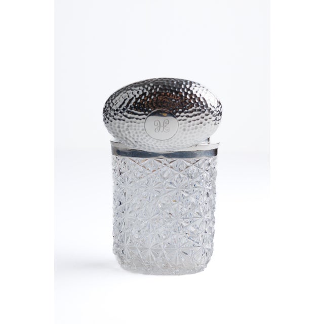 A cylindrical cut crystal jar with beautifully executed all over hobnail and star cutting- a dense, repeating pattern of...