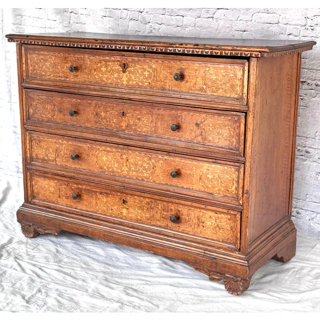 An exquisite 17th century Italian walnut commode with four marquetry inlaid drawers showcasing spectacular and rich inlay...