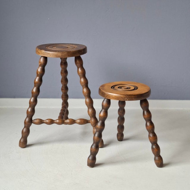 This set of 2 French wooden tripod stools is in good condition. Originally milking stools. Bobbin legs. Sturdy....