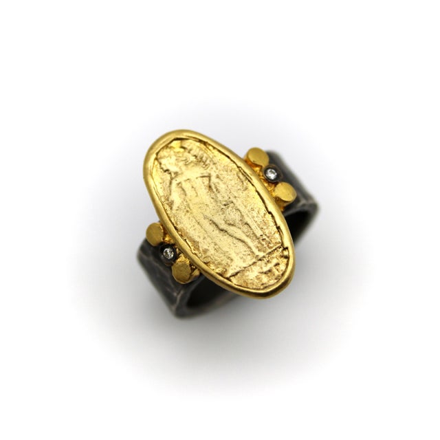 The hand-made, organic quality of this ring makes it an intriguing piece. Its wide, hand-hammered sterling silver band has...