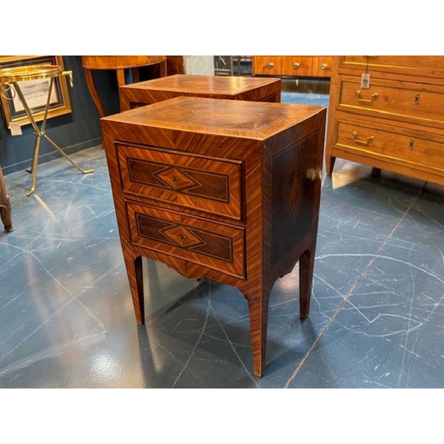 This product is a pair of Italian Neo-Classical inlaid walnut tables from the 19th century. The tables showcase a...