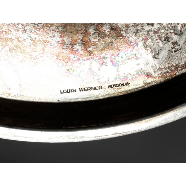 Silver, chased. A wide, rounded foot with a slightly fluted base ring. A disc-shaped knop with chased, subtle, fruit-like...