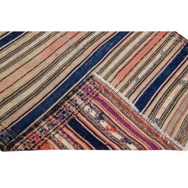 Beautiful kilim handmade wool runner with a peach field. This Vintage flatweave rug has beige and blue accents features a...