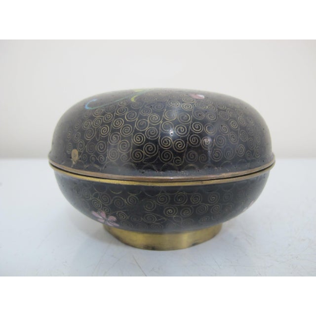 Very sweet vintage Chinese Cloisonne box with lid. Round in black enamel with hand painted gold coil and green, pink, and...