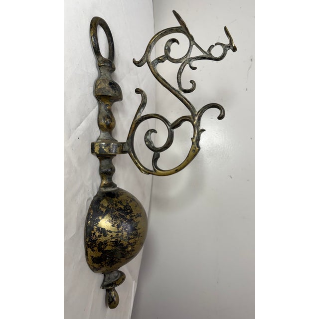 The antique 18th century 2 piece Dutch brass wall hook is a rare and elegant piece that exudes historical charm. The gold...