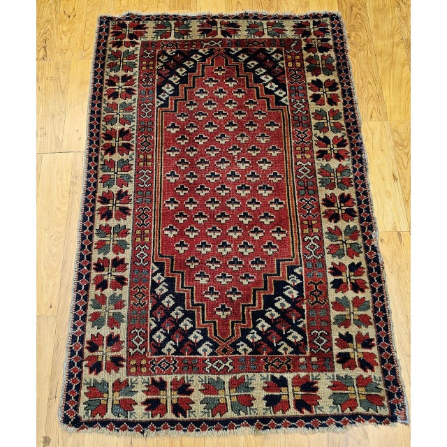 A vibrant mid-20th century vintage Turkish village area rug of outstanding energy and color — its brilliant red field...