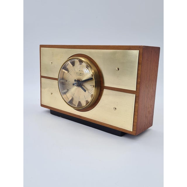 An elegant table clock manufactured in Germany by Weimar, featuring the distinctive aesthetics of 1970s modernism. The...