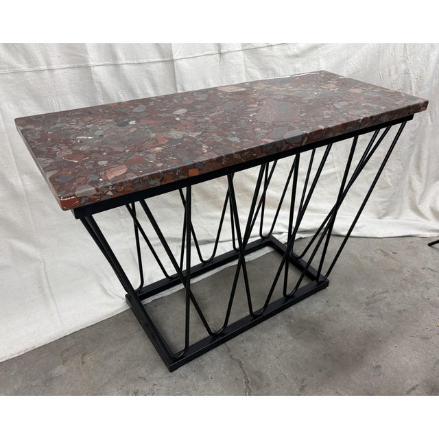 A striking console table featuring a honed Breccia marble top and a hand‑formed steel base by metalworker Jon Little. The...