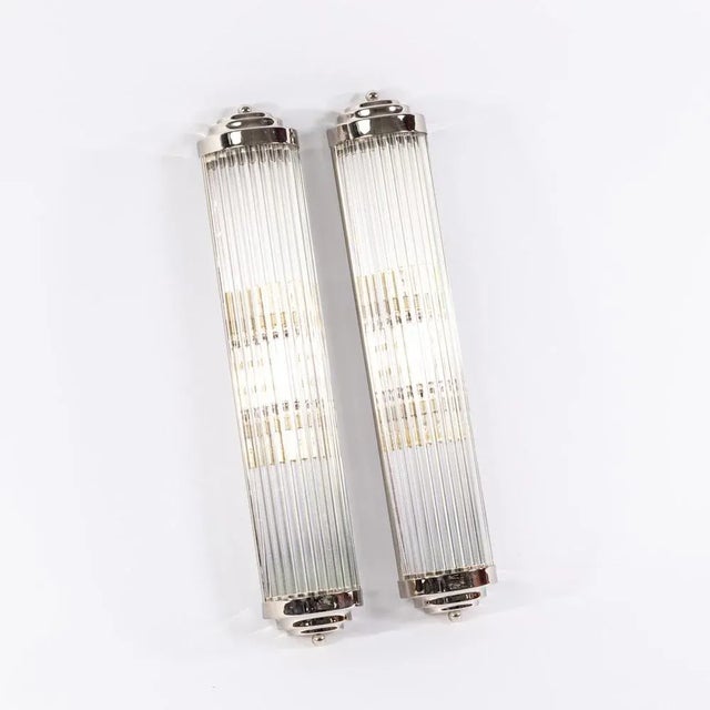 This Art Deco-style wall lamp makes a confident statement. Elaborately crafted glass rods elegantly refract the light,...