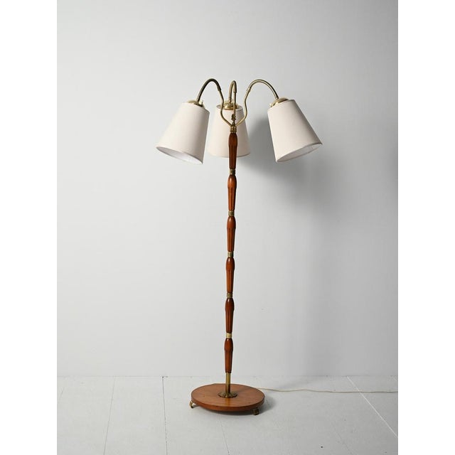 Mid-century floor lamp in turned teak and brass with three adjustable arms and adjustable heads. Elegant Scandinavian...
