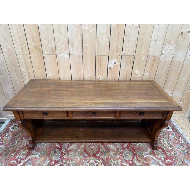 A solid walnut neo-renaissance style console table, made in lyon between 1890 and 1910. the symmetrical structure features...