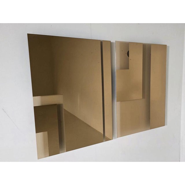 Pair of Andromeda mirrors designed by Nanda Vigo in 1974 and produced by Glas Italia. Executed in amber-tinted mirrored...