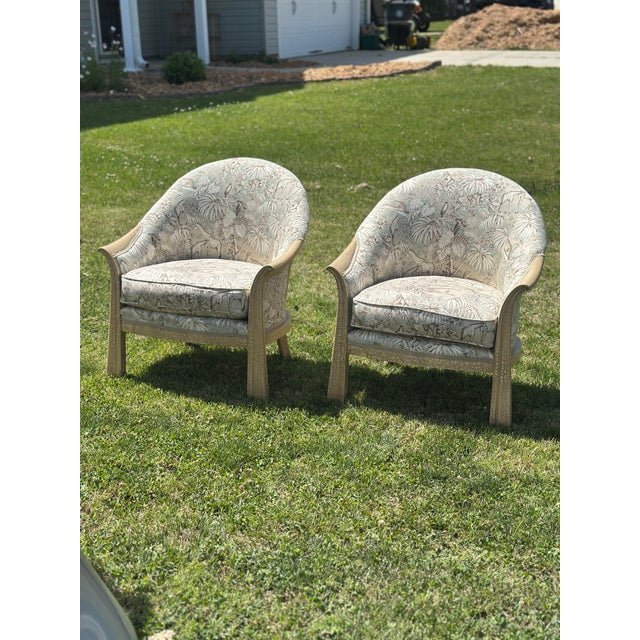 A stylish pair of vintage barrel-back lounge chairs upholstered in an elegant safari-inspired fabric featuring giraffes,...