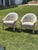 A stylish pair of vintage barrel-back lounge chairs upholstered in an elegant safari-inspired fabric featuring giraffes,...