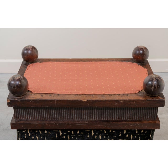 Small rectangular footstool on four solid spherical legs with an upholstered top and original springs. The walnut base...