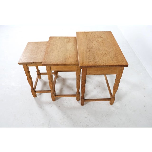 A set of three Danish nesting tables crafted in solid oak with glazed ceramic tile tops, circa 1960s. Each table showcases...