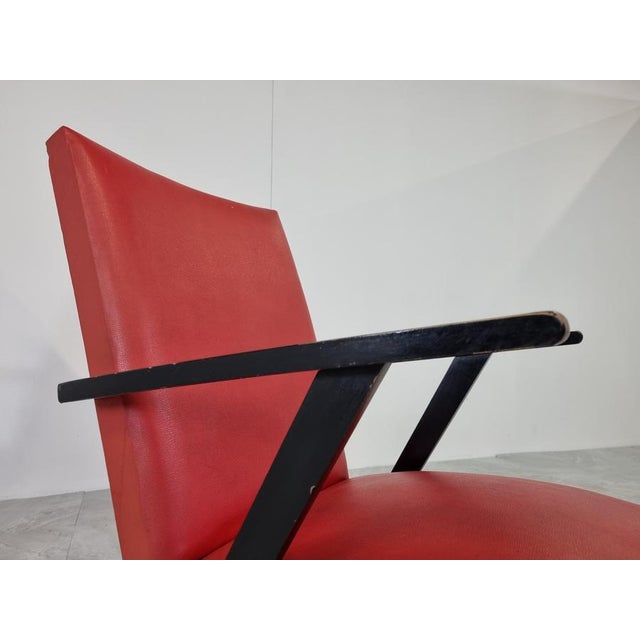Pair of mid century armchairs in red skai (leatherette) upholstery and black lacquered wooden armrests and legs. Nice...