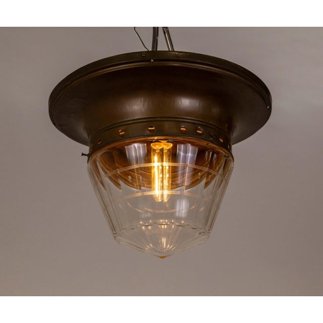 A flush mount light fixture with clear glass in a subtle torpedo shape molded into facets with delicately cut banding...