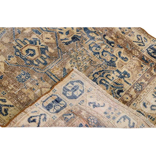 Beautiful Vintage Distressed hand-knotted wool rug with a brown field. This Persian rug has beige frame and blue accents...