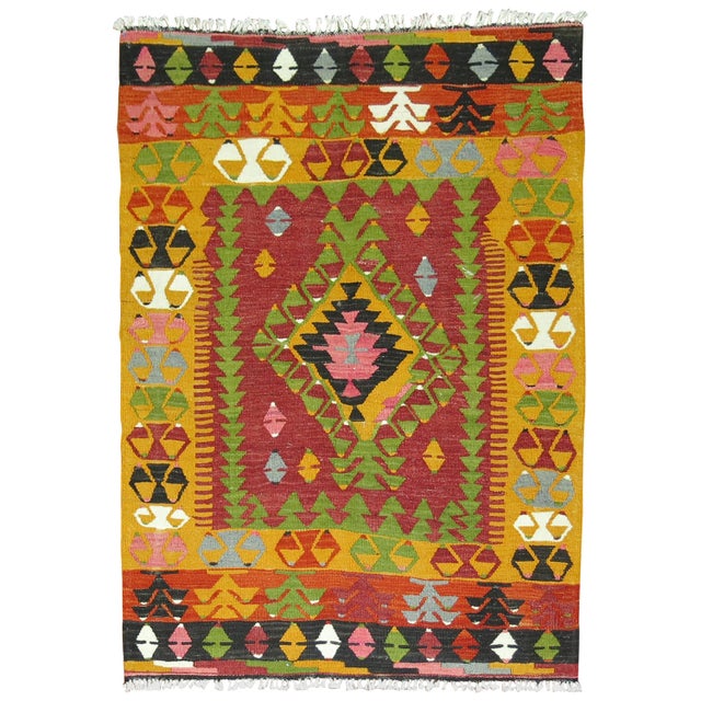 Mid-20th century geometric Turkish Kilim in bright saturated colors. Bright pink, green, red highlight this delightful...