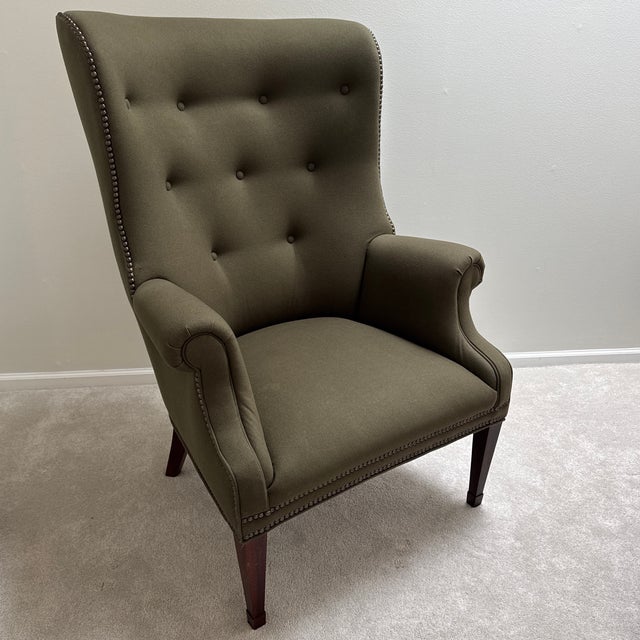 This gently loved ‘Isaac’ wing chair by Hickory Chair Furniture Company is a transitional piece featuring exquisite olive...