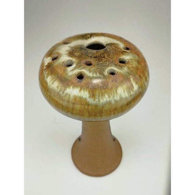 This beautiful vase, with its vibrant, flowing glaze in earthy colors and its organic, mushroom-like shape, is typical of...