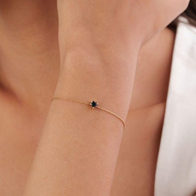 This minimalist chain bracelet features a delicate 0.31 ct heart-cut blue sapphire, set in 14K yellow gold. The sapphire...
